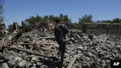 An Afghan security police walks at the destroyed house after an operation in Asad Khil near the site of a U.S. bombing in the Achin district of Jalalabad, east of Kabul, Afghanistan, Saturday, April 17, 2017.