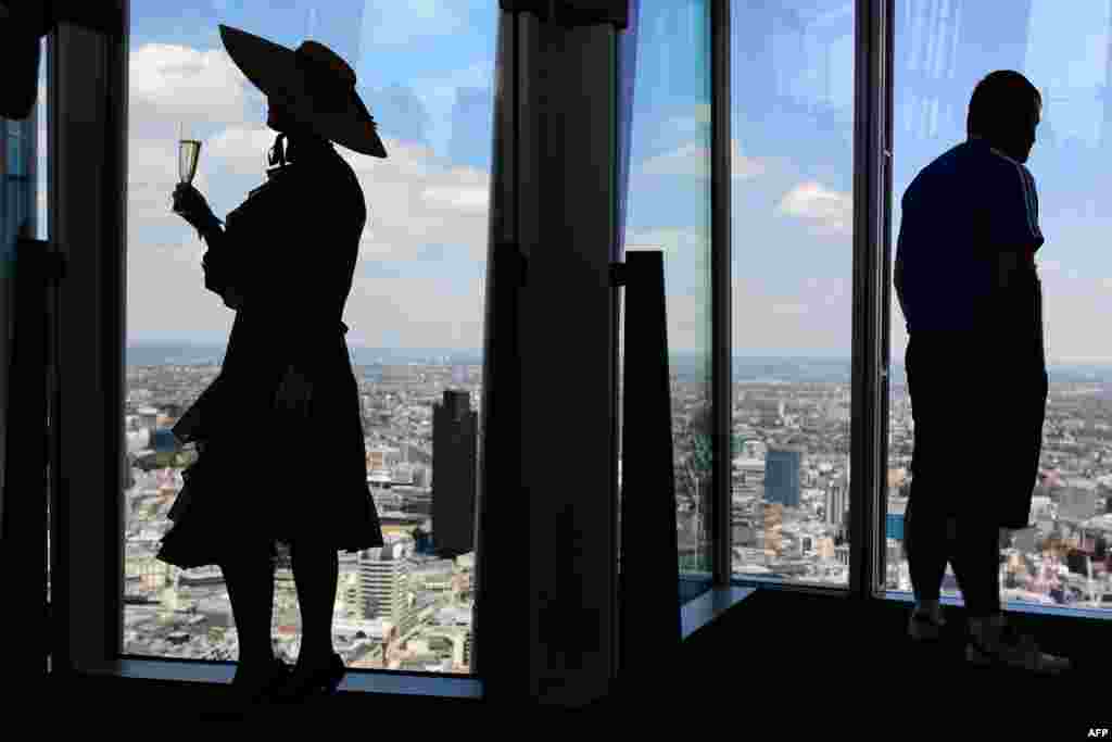 A member of the Chap Olympiad group known as &quot;Auntie Maureen&quot; (L) poses for photographs at the press launch of London&#39;s highest lawn in the Shard building, Britain.