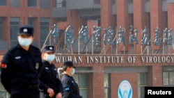 FILE - Security personnel keep watch outside the Wuhan Institute of Virology during a visit by a World Health Organization team, in Wuhan, Hubei province, China, Feb. 3, 2021.