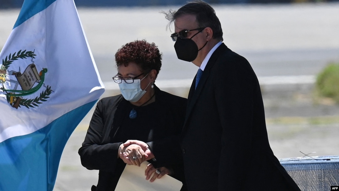 La ministra de Salud de Guatemala, María Amelia Flores saluda al canciller mexicano, Marcelo Ebrard, a su llegada a la Base Aérea de la Ciudad de Guatemala, el 24 de junio de 2021.