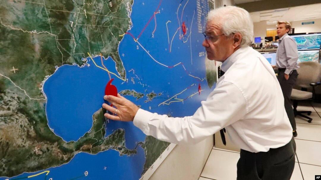 National Oceanic and Atmospheric Administration public affairs officer Dennis Feltgen updates the progress of Hurricane Michael on a large map, Oct. 9, 2018, at the Hurricane Center in Miami. 