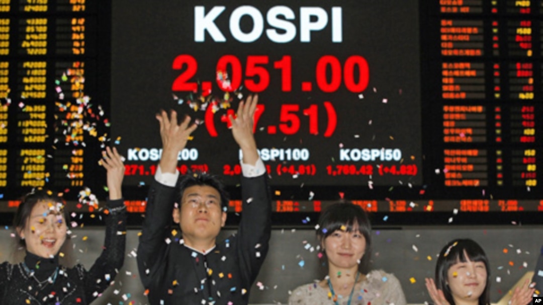 Employees of the Korea Exchange applaud in front of the final stock price index for the ceremonial closing of the 2010 stock market at the Korea Exchange, Seoul, 30 Dec 2010