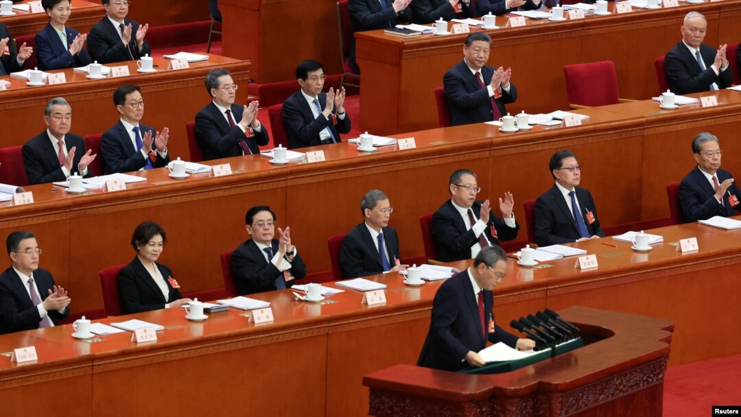 Chinese President Xi Jinping and other officials applaud as Premier Li Qiang concludes his work report at the opening session of the National People's Congress at the Great Hall of the People in Beijing, March 5, 2025. 