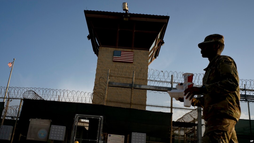 FILE - In this June 5, 2018 photo, reviewed by U.S. military officials, a task force member walks past the Camp 6 detention facility at the Guantanamo Bay U.S. Naval Base, Cuba. 