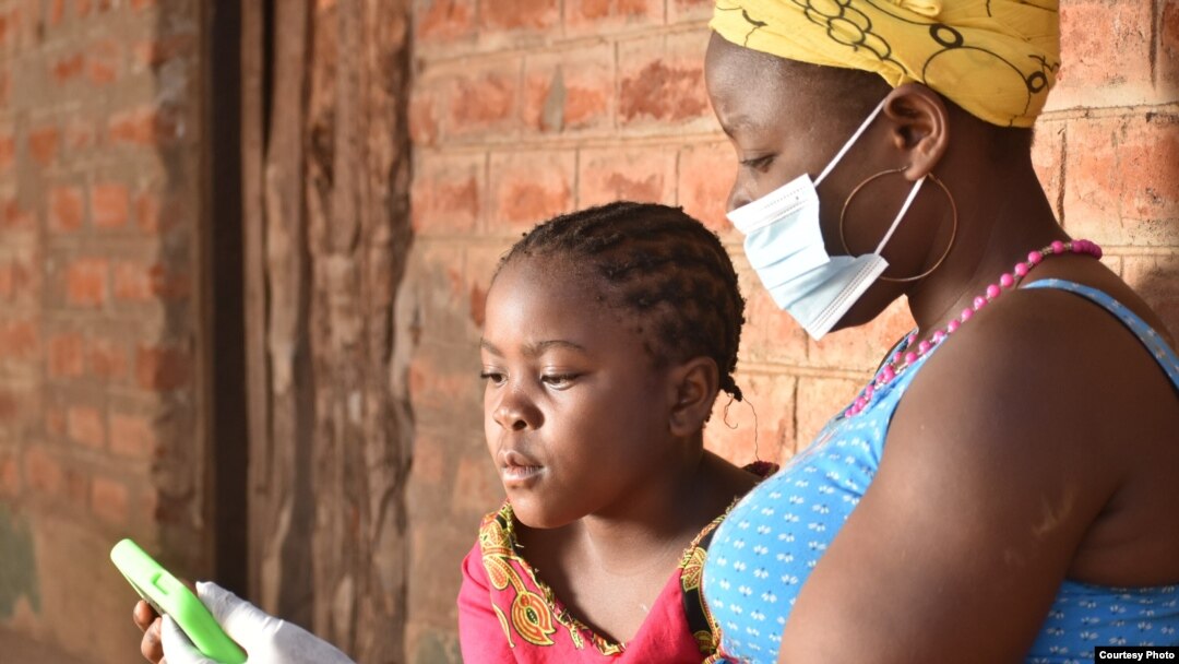 A student works with her mother on a lessons using a tablet provided by British charity Voluntary Services Overseas, in Malawi. (Photo courtesy of VSO/Craig Mawanga)