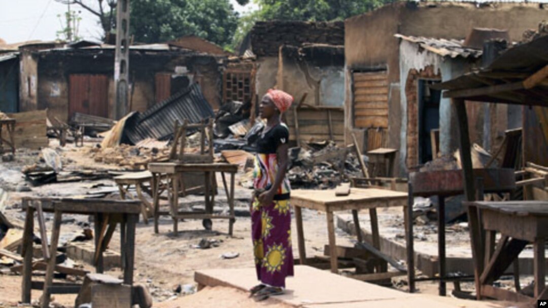 Wata mata 'yar Nigeria ce ke kallon gidajen da aka kokkona a lokacin rikicin zaben Nigeria a kauyen Kachia, kudancin jihar Kaduna.