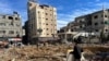 Palestinians inspect damages following an Israeli raid at Kamal Adwan hospital in the northern Gaza Strip