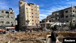 Palestinians inspect damages following an Israeli raid at Kamal Adwan hospital in the northern Gaza Strip