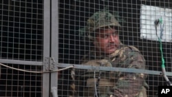 FILE - An Indian army soldier looks from inside an army vehicle at the Indian air force base in Pathankot, India, Jan. 4, 2016.