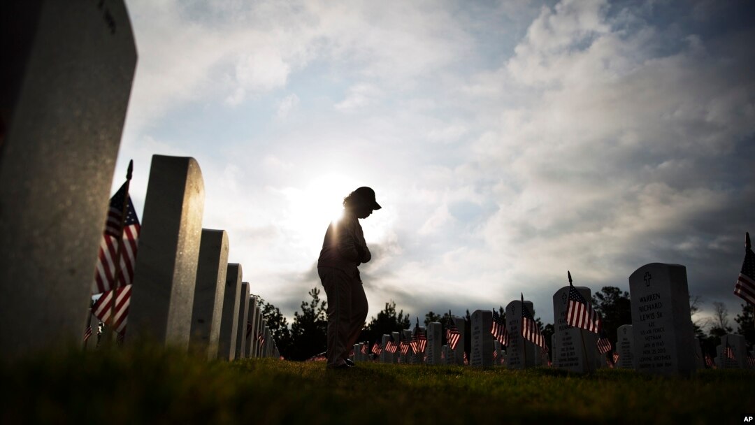 Lucille Williams walks through Georgia National Cemetery while visiting the grave of her late husband, Korean War veteran Sgt. 1st Class Alvin Williams, in honor of Memorial Day, May 25, 2015, in Canton, Ga. (AP Photo/David Goldman)