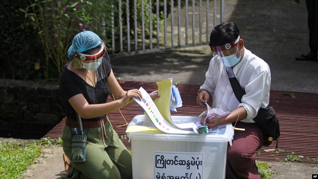 Officers from Union Election Commission arrange ballots for an early voting for upcoming Nov. 8 general election outside a residence on the outskirts of Yangon, Myanmar, Oct. 29, 2020.