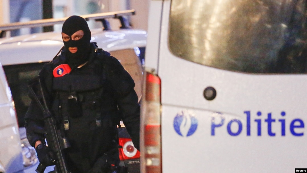 FILE - A Belgian special forces police officer patrols a street during a police raid in central Brussels, Belgium, Dec. 20, 2015. The ninth suspect arrested is believed to have been in contact via telephone with the cousin of the alleged organizer of the attacks.