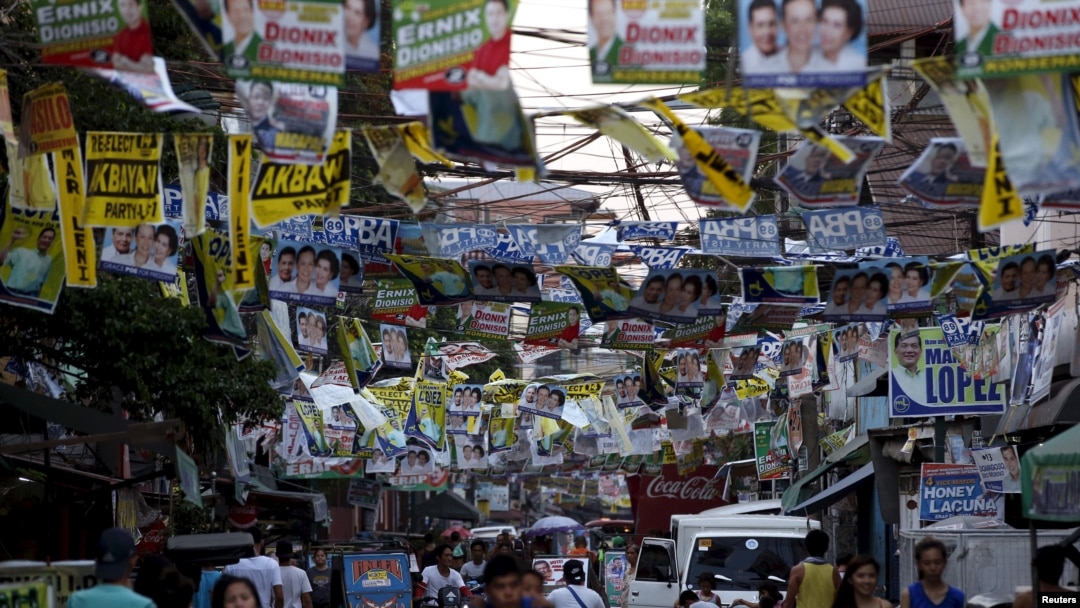 Election posters for the 2016 national elections hang above a busy road in Tondo, Manila, April 26, 2016. 