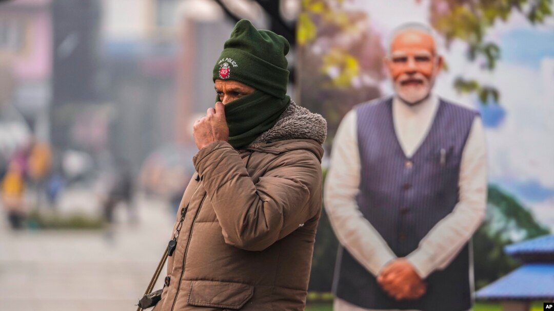 An Indian police officer stands guard near a cutout portrait of Indian Prime Minister Narendra Modi displayed at the main market in Srinagar, Indian-controlled Kashmir, Dec. 11, 2023.