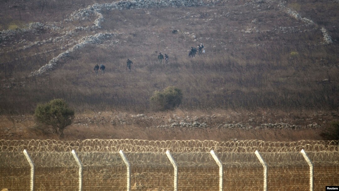 Rebel fighters are seen in Syria near the border fence with the Israeli-occupied Golan Heights, Sept. 2, 2014. 
