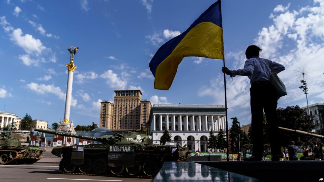 A woman looks over a row of destroyed Russian military vehicles on display at Maidan Square in Kyiv, Ukraine, Tuesday, Aug. 23, 2022. Kyiv official have banned mass gatherings through Thursday for fear of Russian missile attacks. (AP Photo/David Goldman)