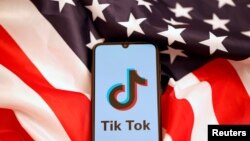美國國旗和手機上顯示的Tiktok標識。