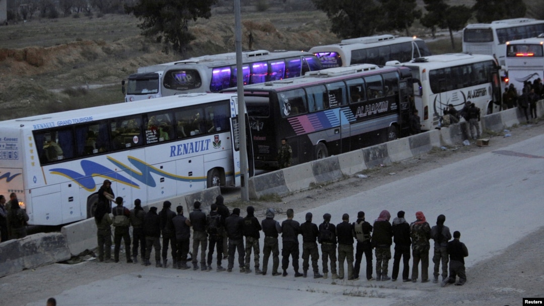Rebel fighters pray before they are evacuated, outside Harasta in eastern Ghouta, in Damascus, Syria, March 23, 2018. 
