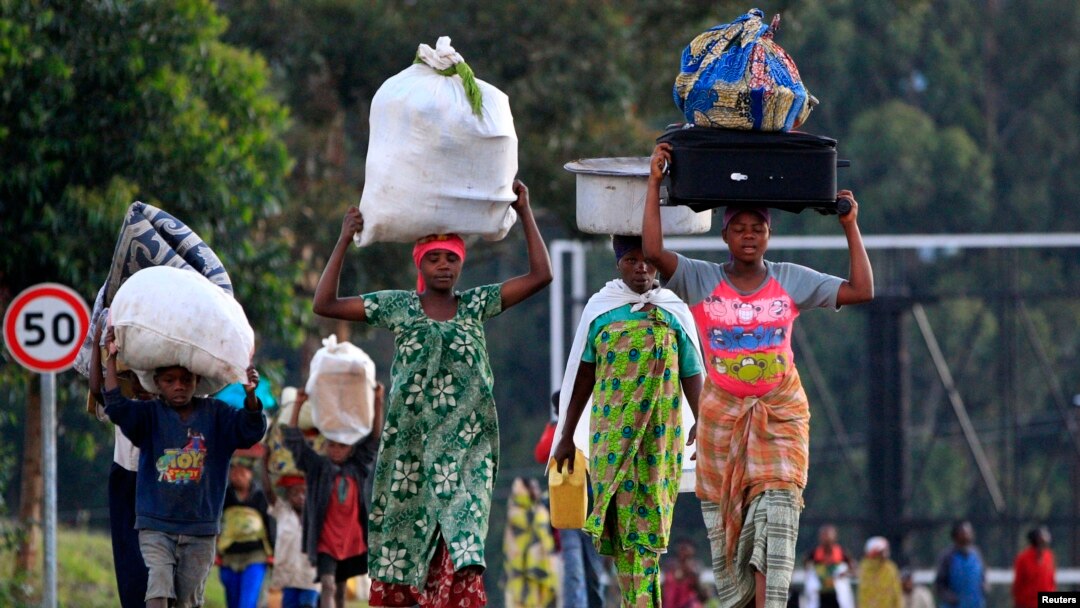 People displaced by fighting between Congolese forces and M23 rebels make their way home after spending a night in the Ugandan town of Bunagana, Oct. 31, 2013.
