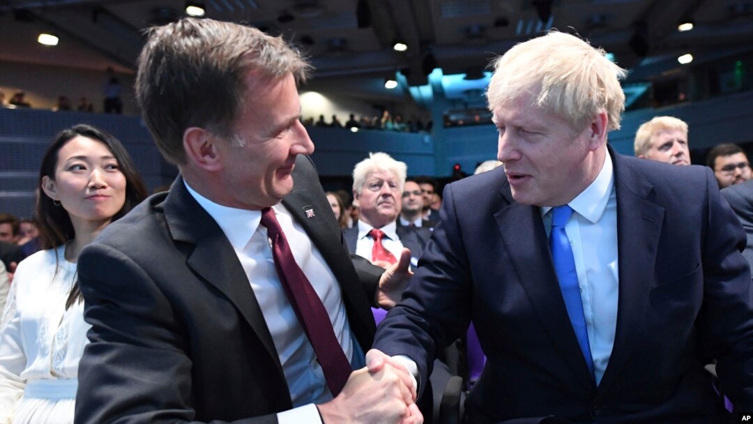 Jeremy Hunt, left, congratulates Boris Johnson after the announcement of the result in the ballot for the new Conservative party leader, in London, Tuesday, July 23, 2019.