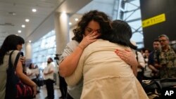 María Hastings, quien vive en Florida, EEUU, abraza por primera vez a su madre biológica a su llegada al aeropuerto de Santiago, Chile, el domingo 18 de febrero de 2024. 