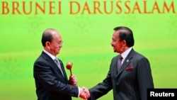 Burma's President Thein Sein (L), shakes hands with Brunei's Sultan Hassanal Bolkiah after receiving the ASEAN Gavel during the Closing Ceremony of the 23rd ASEAN Summit, Bandar Seri Begawan, Oct. 10, 2013. 