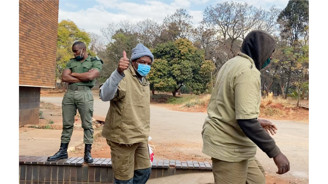 Journalist Hopewell Chin’ono gives a thumbs-up to reporters as he leaves Harare Magistrates Court, Aug. 7, 2020, after launching a third bail application. (Columbus Mavhunga/VOA)
