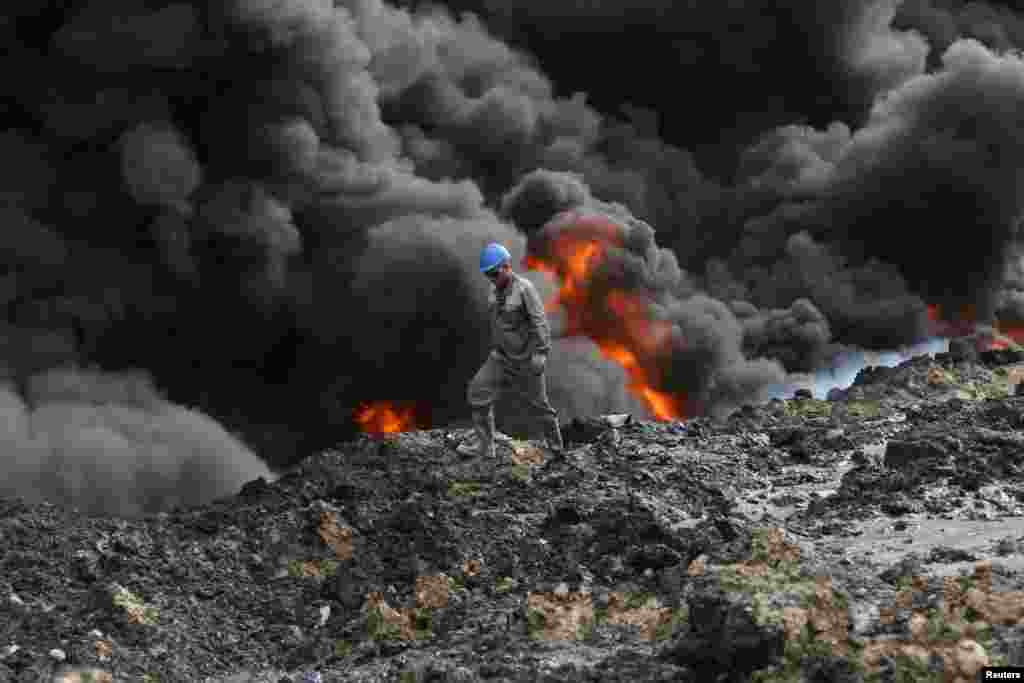 Smoke rises from oil wells set ablaze by Islamic State militants before fleeing the oil-producing region of Qayyara, Iraq, Nov. 1, 2016.