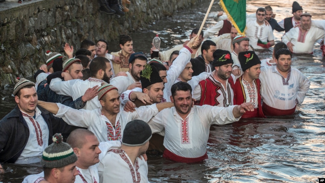 Bulgarians sing and chain dance in the icy waters of the Tundzha river during Epiphany, in Kalofer, Bulgaria, Jan. 6, 2020. 