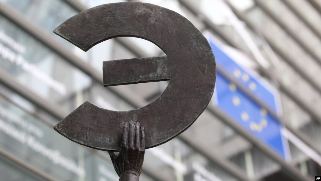 A statue shows the Euro symbol flipped, at the European Commission headquarters in Brussels, Belgium, March 7, 2012. 