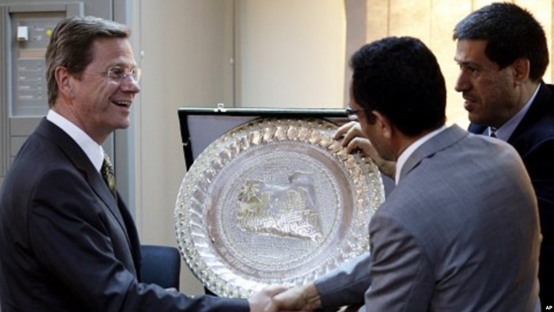German Foreign Minister Guido Westerwelle (L) shakes hands with Libyan rebel National Transitional Council vice chairman and official spokesman Abdel Hafiz Ghoga after a news conference in Benghazi, Libya, June 13, 2011
