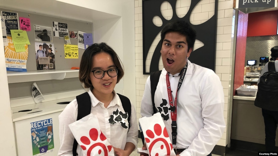 Asian Americans Advancing Justice interns Dieu Linh Nguyen, left, and Tauheed Islam got free sandwiches July 8 at a Chick-fil-A cow appreciation event. (A. Peng)
