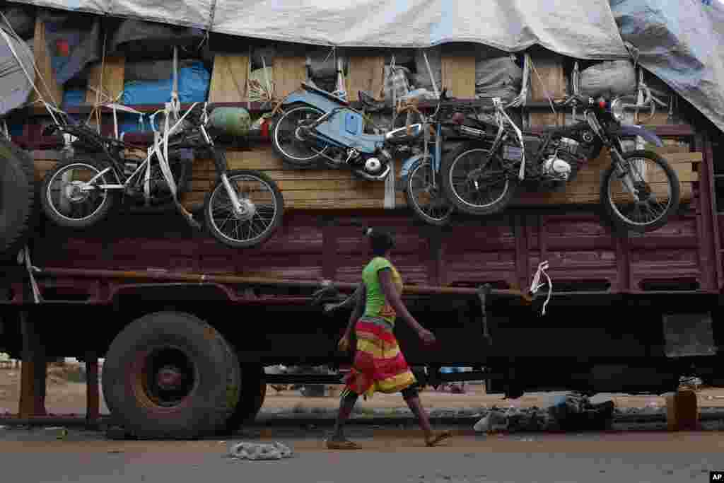 A woman walks past a truck waiting to leave for Chad loaded with goods belonging to Muslim residents of the PK5 district of Bangui, Central African Republic, April 9, 2014.