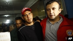 Washington Nationals' catcher Wilson Ramos, left, is seen at the Criminal Police (CICPC) headquarters accompanied by Venezuela's Justice Minister Tareck El Aissami in Valencia, Venezuela, November 12, 2011.