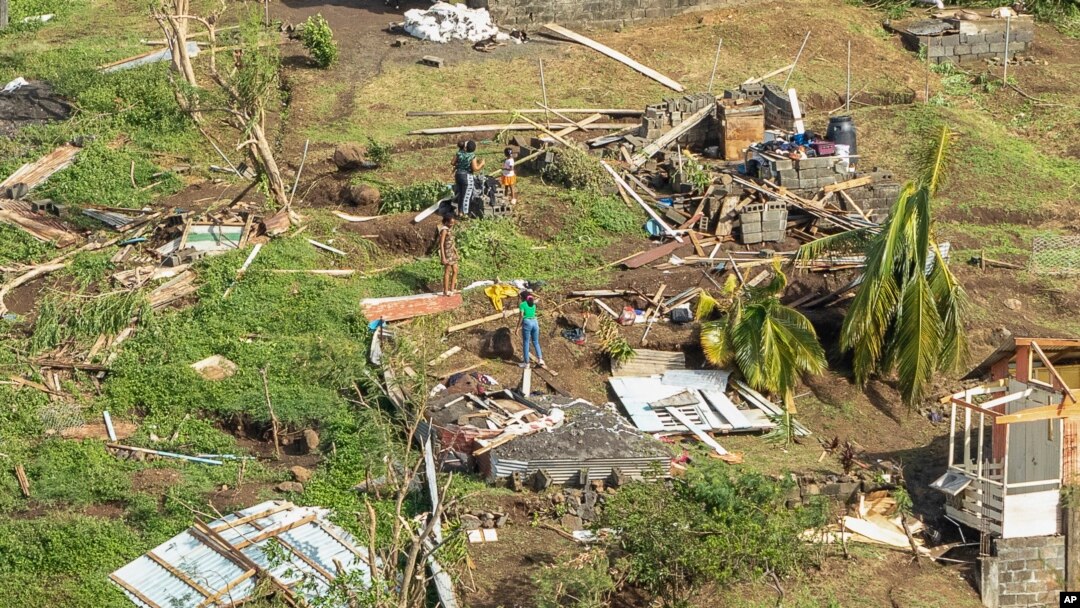 Family members survey their home, which was destroyed in the passing of Hurricane Beryl, in Ottley Hall, St. Vincent and the Grenadines, on July 2, 2024.