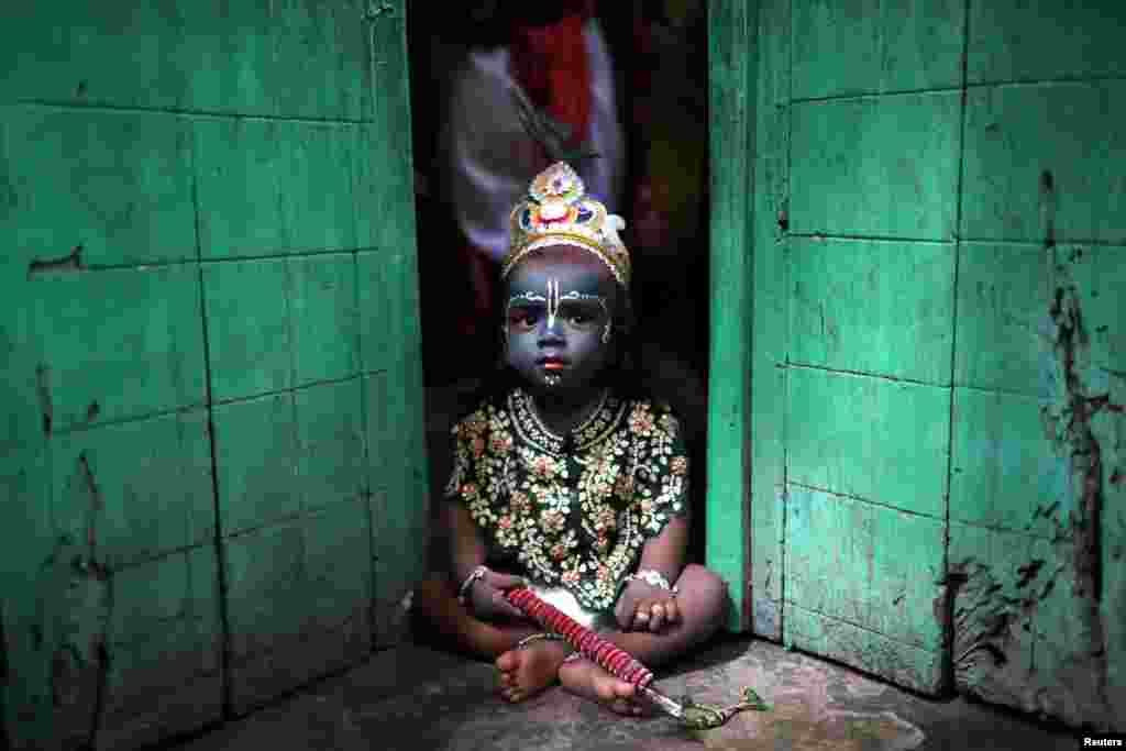 A child dressed as Lord Krishna during Janmashtami festival, sits on a doorstep in Dhaka, Bangladesh. The festival marks the birth anniversary of Lord Krishna.