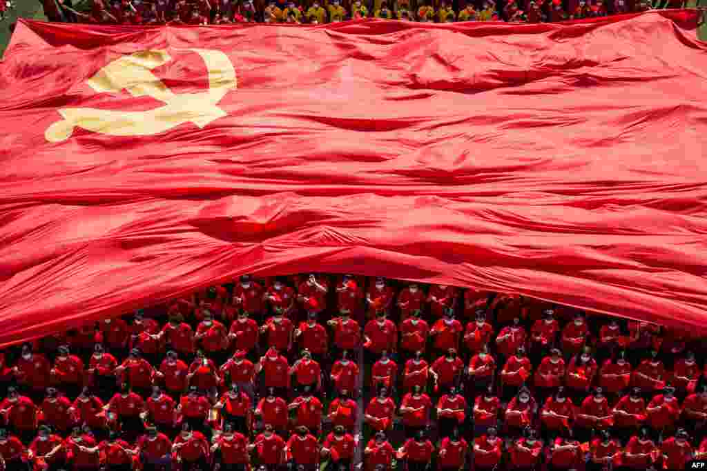 University students display a flag of the Communist Party of China to mark the party&#39;s 100th anniversary during an opening ceremony of the new semester in Wuhan in China&#39;s central Hubei province.
