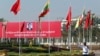 A traffic police stands on a road as he clears a road near a welcoming billboard to Chinese President Xi Jinping Friday, Jan. 17, 2020, in Naypyitaw, Myanmar.