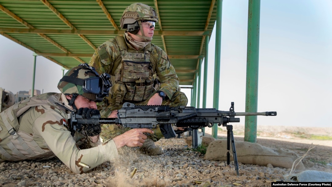 An Australian Army trainer observes an Iraqi Army soldier from the Ninewa Operations Command Commando Battalion conduct a live fire shoot with the M249 machine gun at the Taji Military Complex, Iraq. 