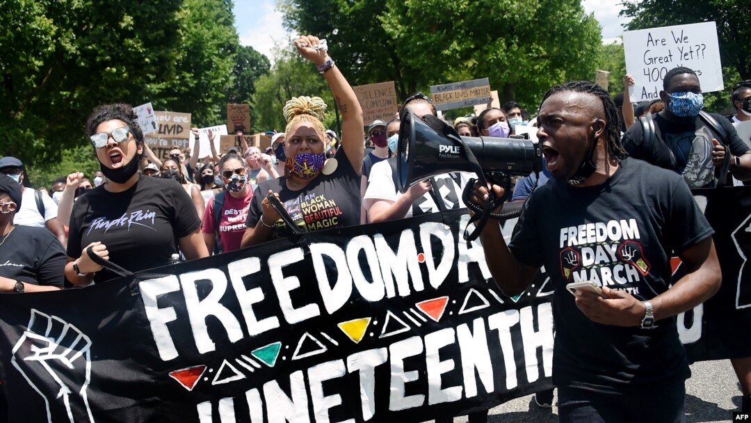 FILE - Demonstrators take part in a Juneteenth march and rally in downtown Washington, June 19, 2020.