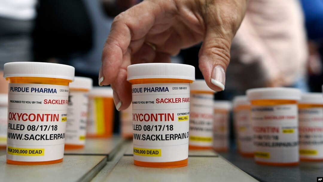 FILE -Family and friends who have lost loved ones to OxyContin and opioid overdoses leave pill bottles in protest outside the headquarters of Purdue Pharma, which is owned by the Sackler family, in Stamford, Conn., Aug. 17, 2018.
