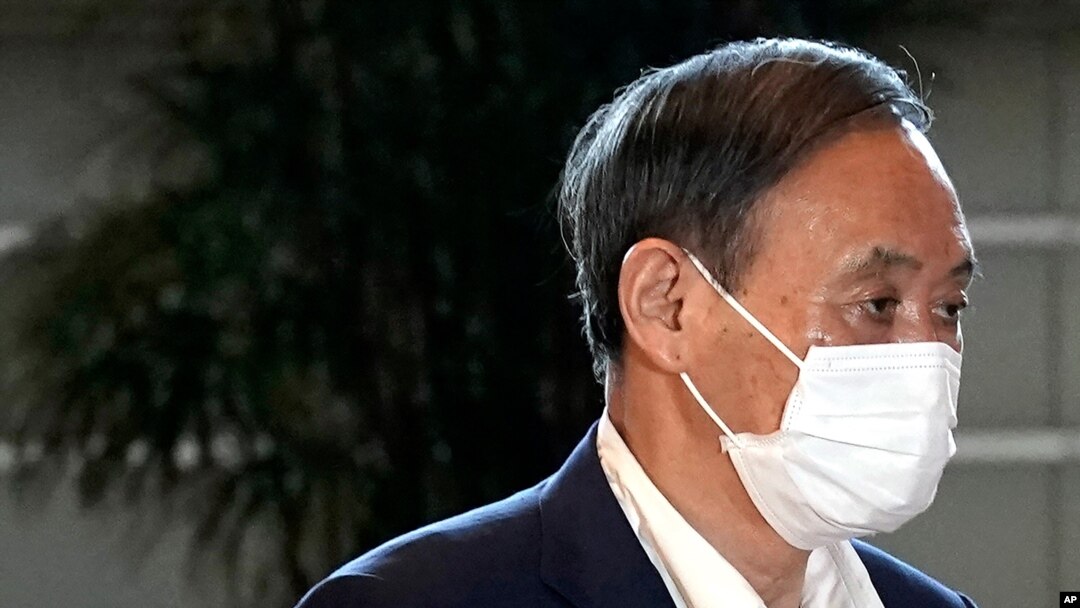 Japan's Chief Cabinet Secretary Yoshihide Suga wears a face mask as he walks to attend Prime Minister Shizo Abe's press conference at the prime minister's office in Tokyo on Aug. 28, 2020.
