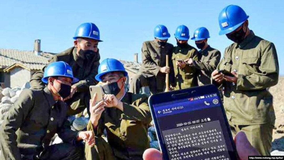 지난 27일 북한 노동신문에 실린 사진. 함경도 수해복구 현장에 투입된 제2수도당원사단 대원들이 스마트폰으로 위문 문자를 읽고 있다.