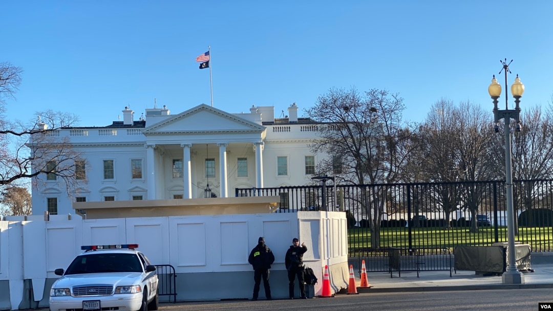 U.S. Secret Service officers stand guard as construction crews work on renovations to the perimeter fence on the North Lawn of the White House, February 27, 2020. (Saqib Ul Islam/VOA)