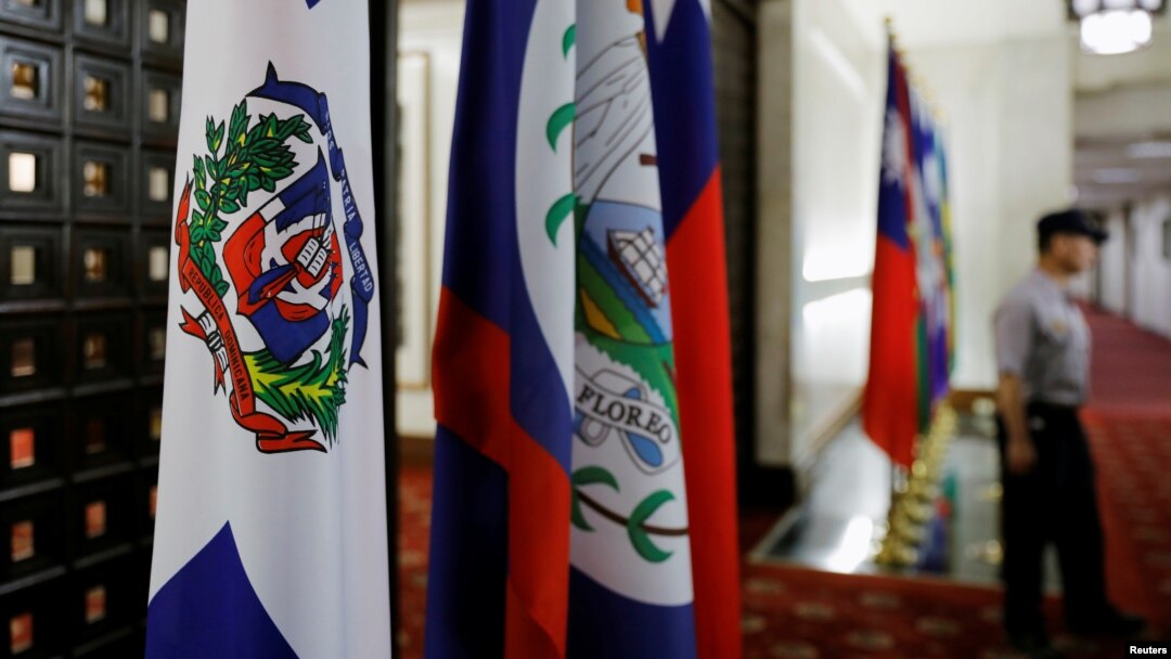 A police officer stands next to the Dominican Republic flag, left, inside the Taiwan's Ministry of Foreign Affairs in Taipei, Taiwan, May 1, 2018. 