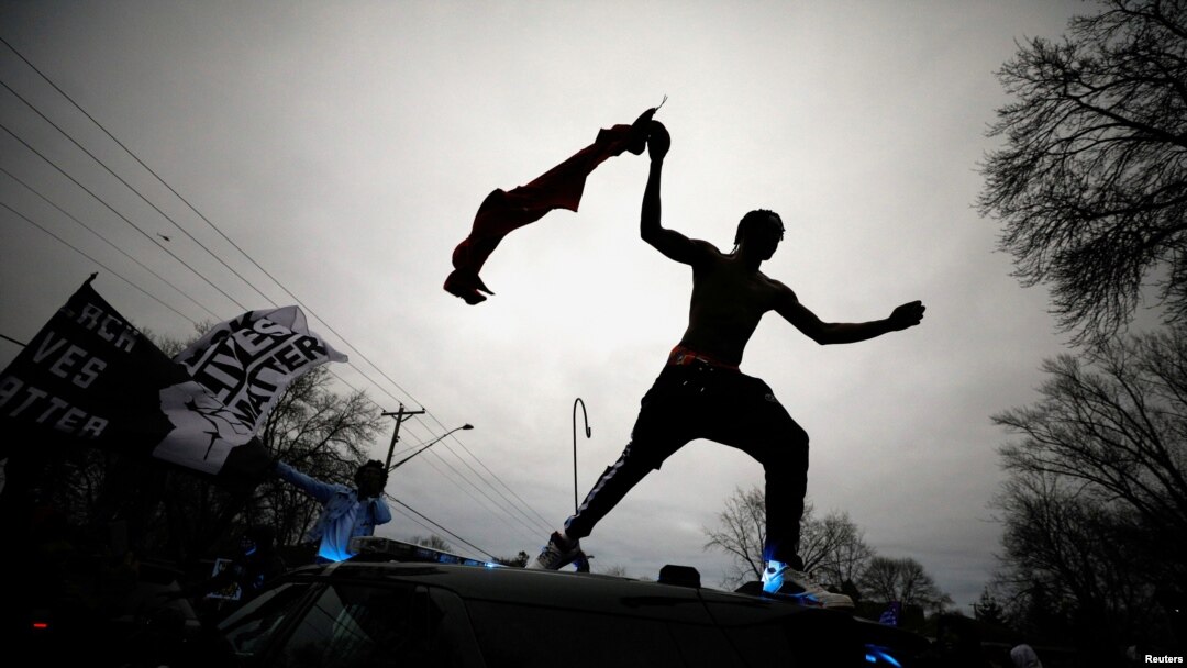 Un manifestante salta de un coche patrullero en medio de las protestas por la muerte del afroestadounidense en Daunte Wright, in Brooklyn Center, Minnesota, el 11 de abril de 2021.