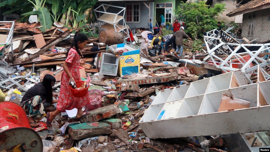 Children affected by the tsunami at Sunda Strait collect snacks from a collapsed shop at Rajabasa in South Lampung, Indonesia, Dec. 25, 2018.
