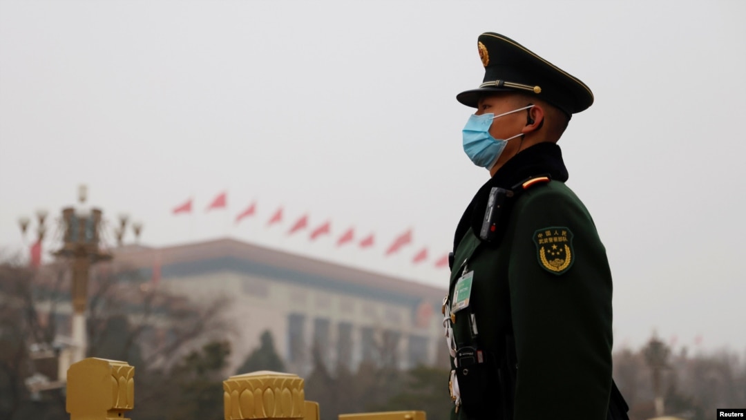 FILE - A paramilitary police officer stands guard near the Great Hall of the People in Beijing, China, March 5, 2021. A U.S. intelligence report released April 13, 2021, warned of China's threat to the U.S.
