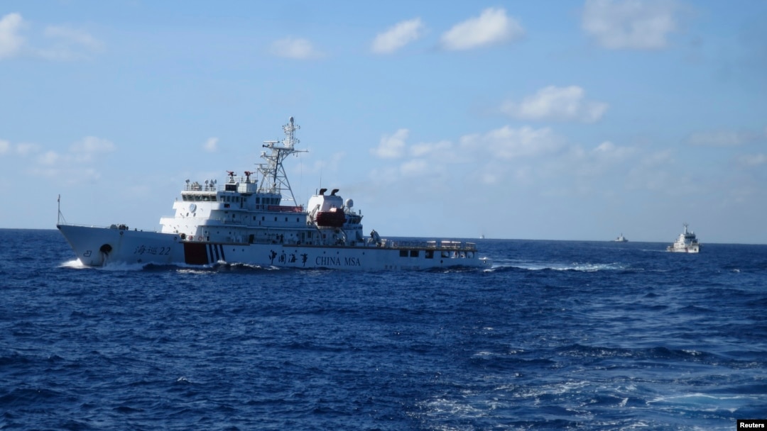 FILE - Chinese ships chase Vietnamese vessels, not shown, after they came within 10 nautical miles of a Chinese oil rig in the South China Sea, July 15, 2014. 