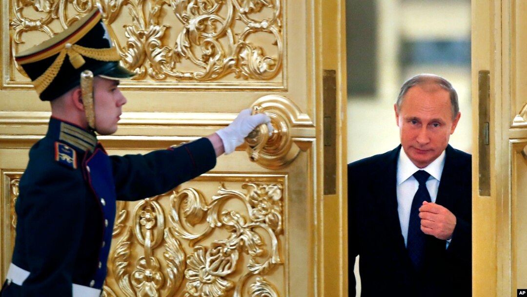 FILE - Russian President Vladimir Putin, right, enters the Alexadrovsky Hall to head a meeting of the Presidential Council for Civil Society and Human Rights at the Kremlin in Moscow, Oct. 2015.